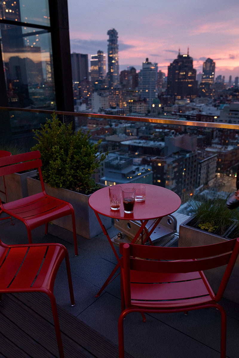 Red folding table with three red chairs.