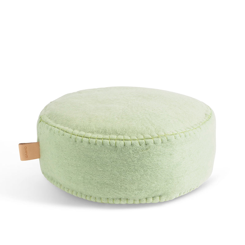 Sage green fabric floor cushion with a white background.