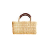 Woven basket with a brown handle on a white background