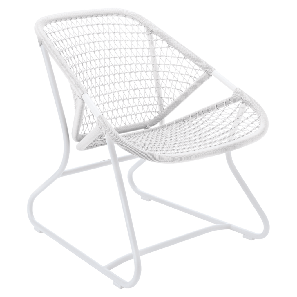 One white low armchair with a criss-cross weave on an aluminum frame.