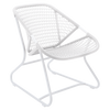 One white low armchair with a criss-cross weave on an aluminum frame.