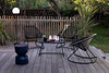 Three black outdoor rocking chairs and table.
