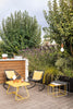 Black outdoor furniture set with a table and chairs on wooden deck.