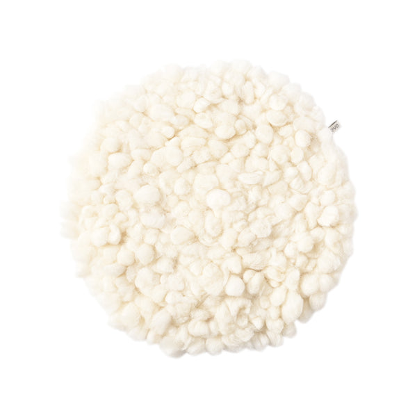 A cream round wool seat cushion with a white background.
