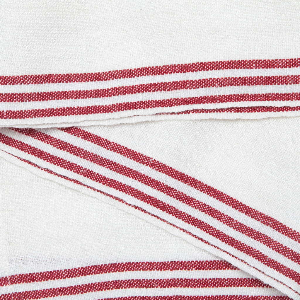White woven fabric with red and white striped borders, shown folded to highlight the textile texture and stripe pattern.