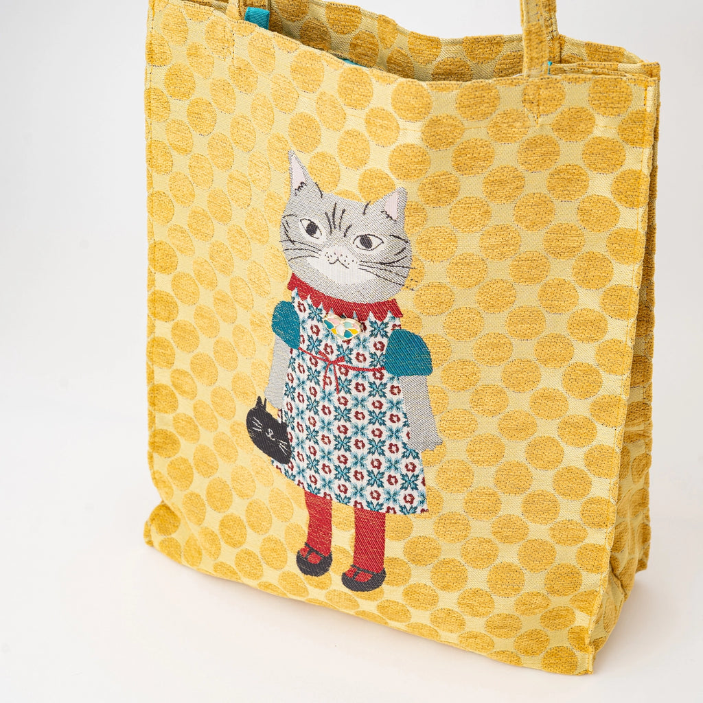 Yellow polka dot tote bag with a cat design on a white background