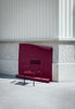 One red Luxembourg armchair against a red background.