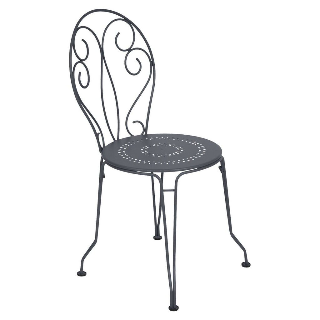 Black outdoor metal chair with hand-forged scrollwork and perforated seat. 