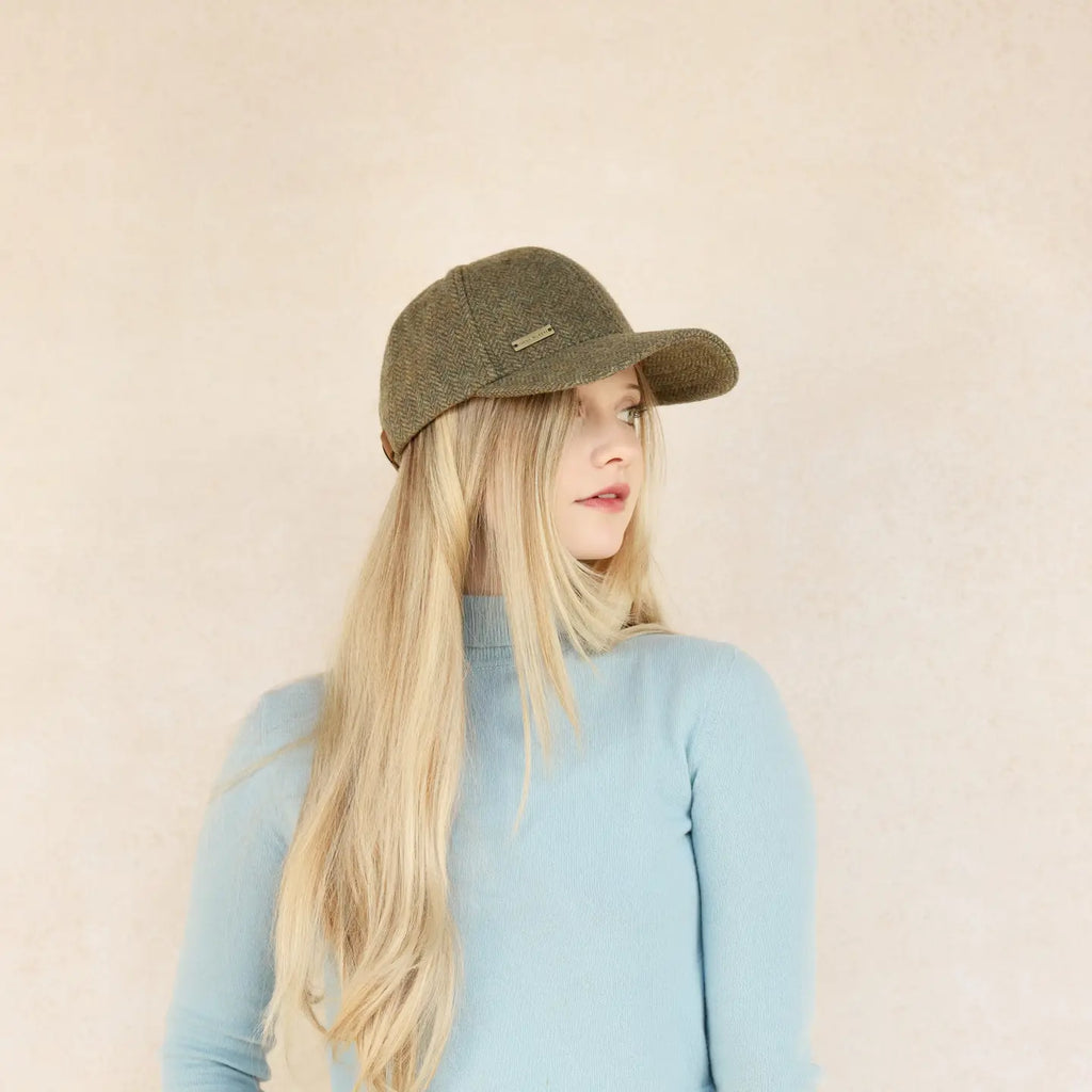 A person wearing a green classic baseball style cap with an adjustable strap, against a neutral background.