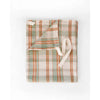 A folded plaid dish towel in muted sage green, terracotta orange, and cream, featuring a matching cream drawstring, shown on a plain white background.