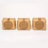 Three square kraft paper packages of J Salt Works sea salt arranged side by side on a clean white background. Q. Dickinson
