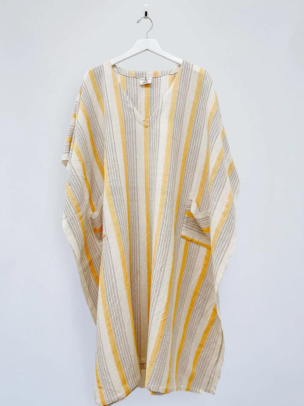 Striped kaftan with yellow and beige pattern on a white background