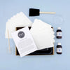 Packaging with white paper, bottles, and a brush on a light blue background