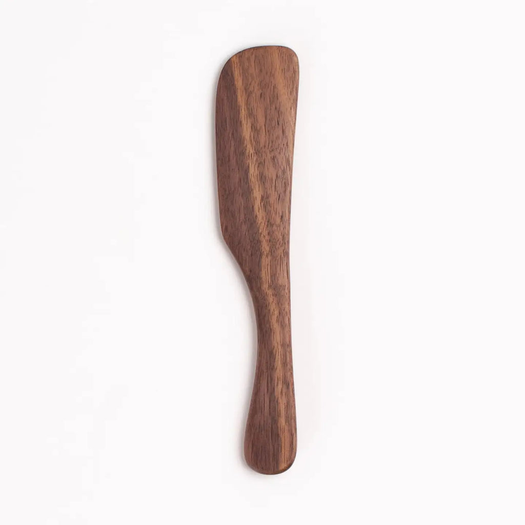 Wooden butter spreader on a white background