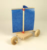 Wooden toy sailboat with a blue sail on a beige background