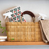 Wicker basket with cleaning supplies on a wooden surface