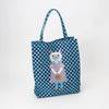 Tote bag with a cat design on a blue polka dot background