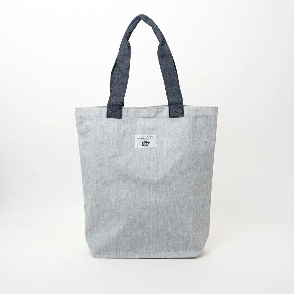 A light gray textured canvas tote bag with dark gray fabric handles and a small white brand label on the front, photographed against a plain white background.