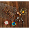 Measuring spoons in stainless steel on a wooden table with bread, eggs and flour.
