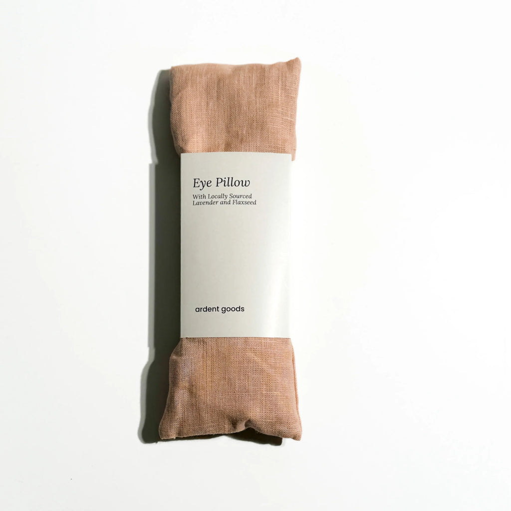 Blush colored eye pillow with packaging on a white background
