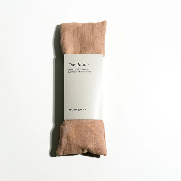 Blush colored eye pillow with packaging on a white background