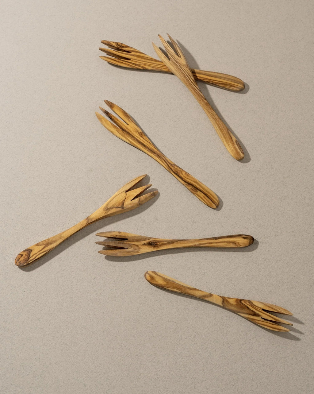 Set of wooden salad servers on a beige background