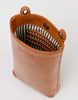 A brown Charlie Phone Bag with a striped cotton lining, featuring a main compartment, three card slots, and a tan strap.