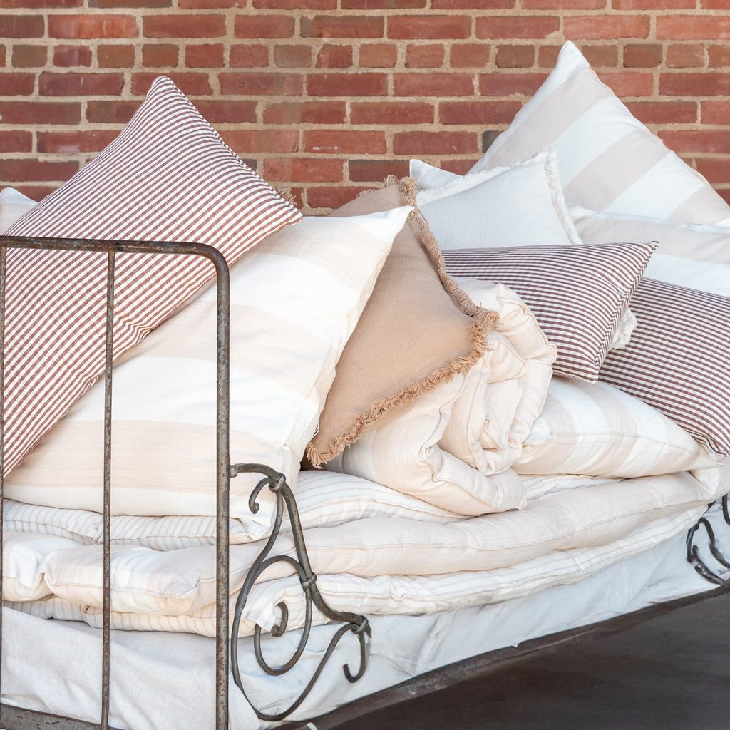 Collection of striped pillows and solid pillows.