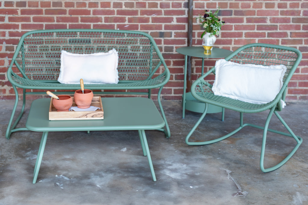 Green outdoor rocking chair, love seat, and table.