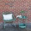 Green outdoor rocking chair with green side table. 