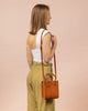 Model wearing Jackie Bag mini in cognac leather