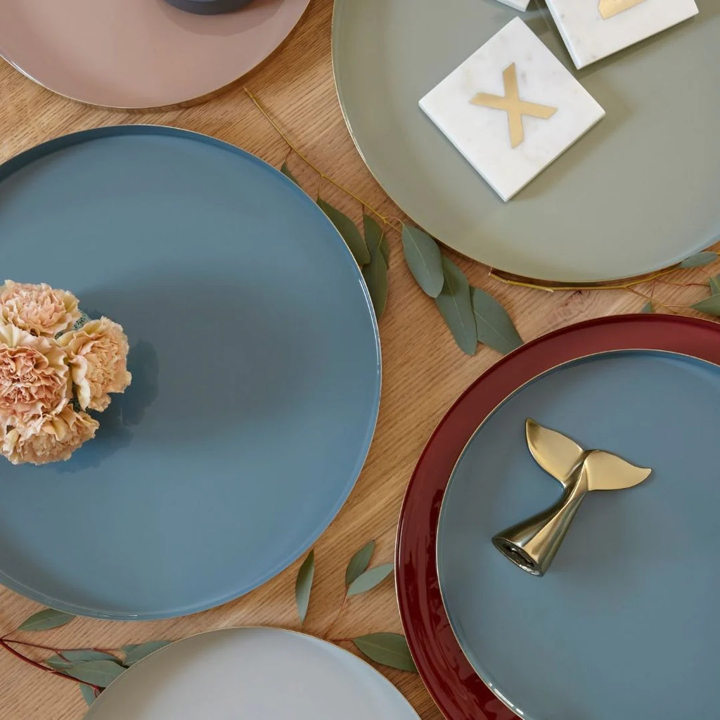 Round serving trays in various colors on a wooden table.