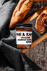 Jar of Fine & Raw chocolate hazelnut butter spread with bread on a wooden board.