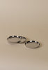 Three polished stainless steel coasters with a shallow lip and central anti-slip pad, displayed on a neutral background.