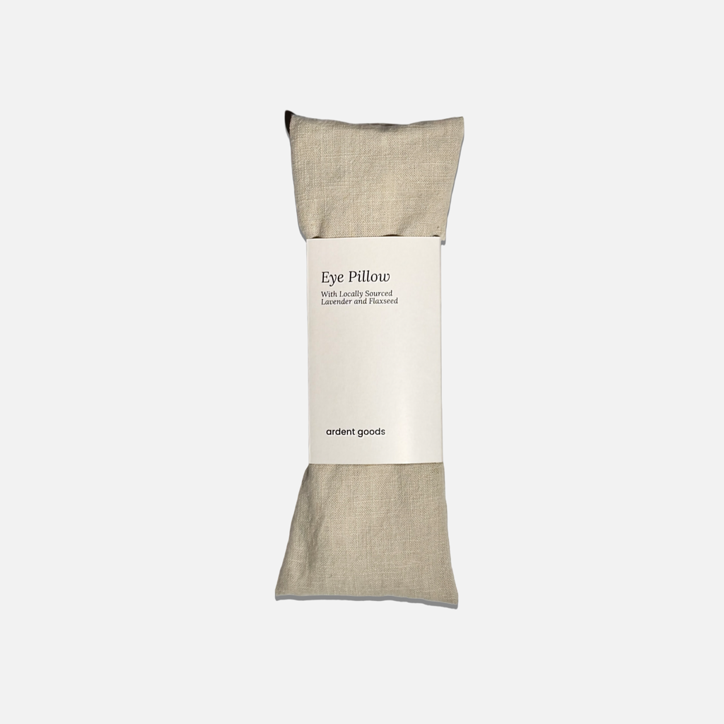 Oatmilk colored eye pillow with a label on a white background