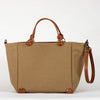 A beige cotton tote bag with brown leather handles and a removable brown leather strap, featuring a zippered closure and an interior pocket, set against a white background.