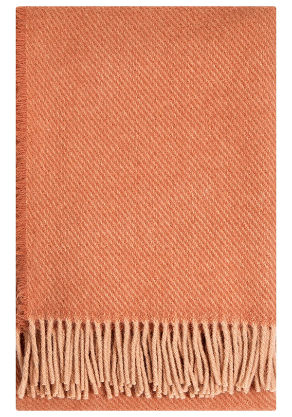 Powder cinnamon-colored throw blanket with fringes on a white background