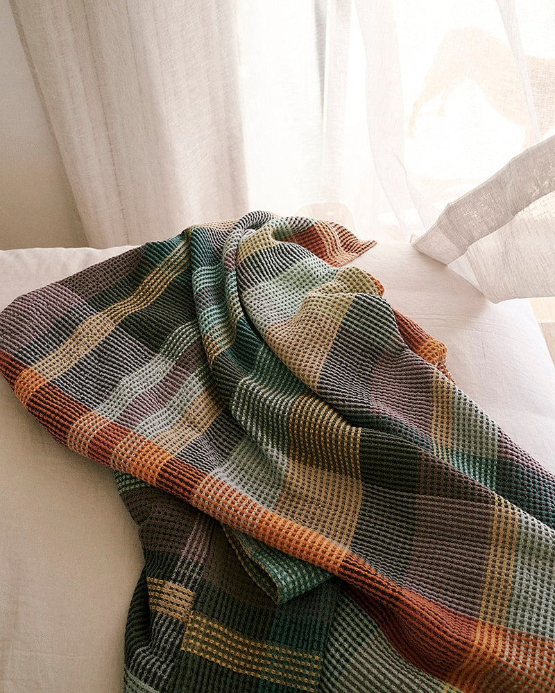 A Mungo 100% cotton blanket on bed.