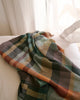 A Mungo 100% cotton blanket on bed.