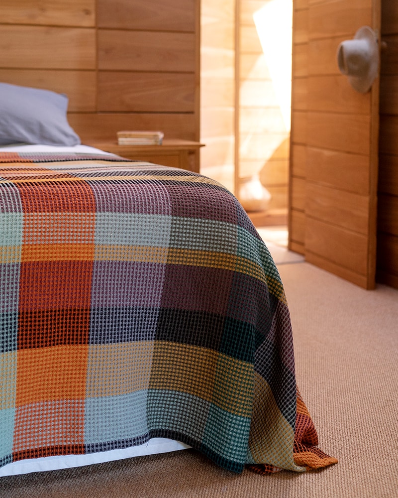 A made bed with a Vrou Mungo 100% cotton blanket