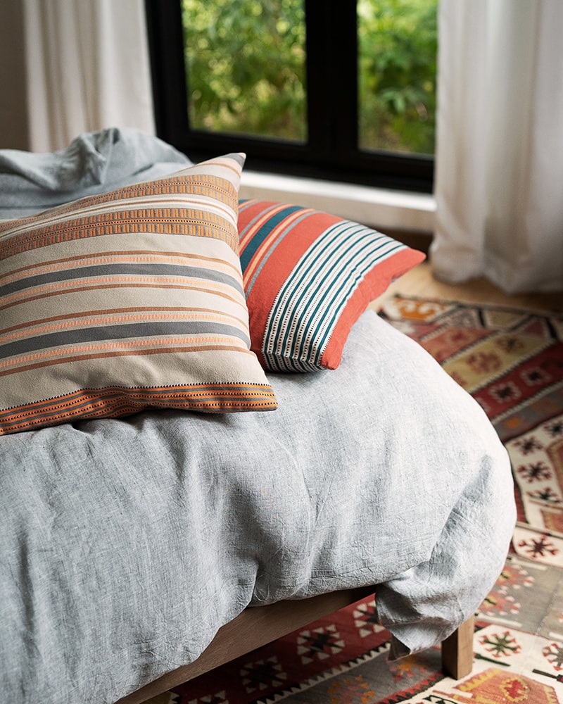 A variety of pillows with different patterns and colors displayed on a couch.