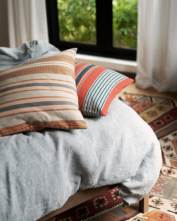 A variety of pillows with different patterns and colors displayed on a couch.
