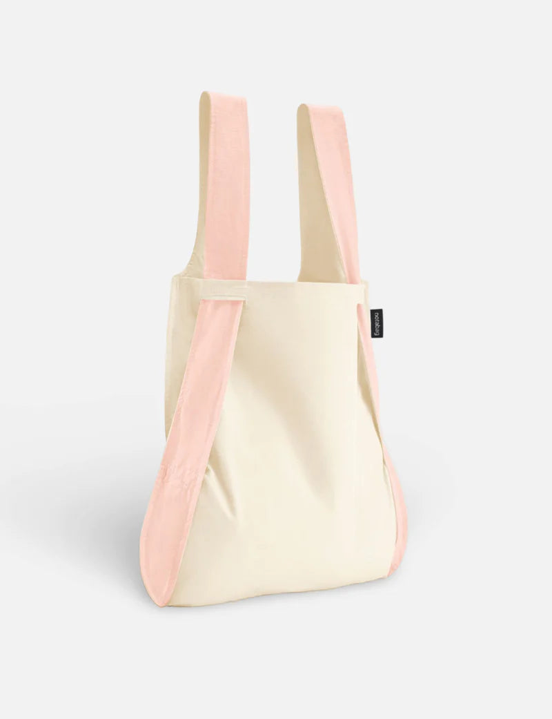 Beige tote bag with pink straps on a light gray background