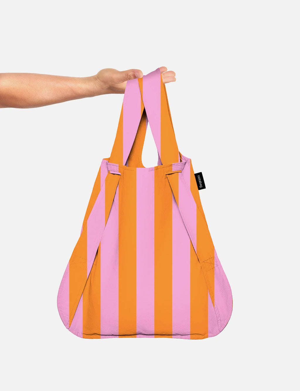 Hand holding a pink and orange striped bag against a white background
