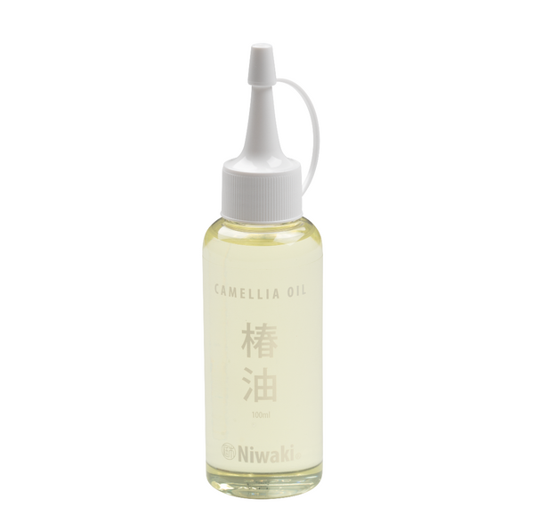A bottle of Niwaki Camellia Oil with a label displaying the product name and Japanese characters, equipped with a dropper nozzle.
