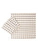 A collection of blue and white hand-dyed cotton table linens, including a tablecloth and napkins, displayed on a white background.