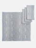 A collection of blue and white hand-dyed cotton table linens, including a tablecloth and napkins, displayed on a white background.