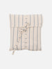 A striped cream and blue cotton throw blanket with fringes and a matching pouch, displayed neatly folded.