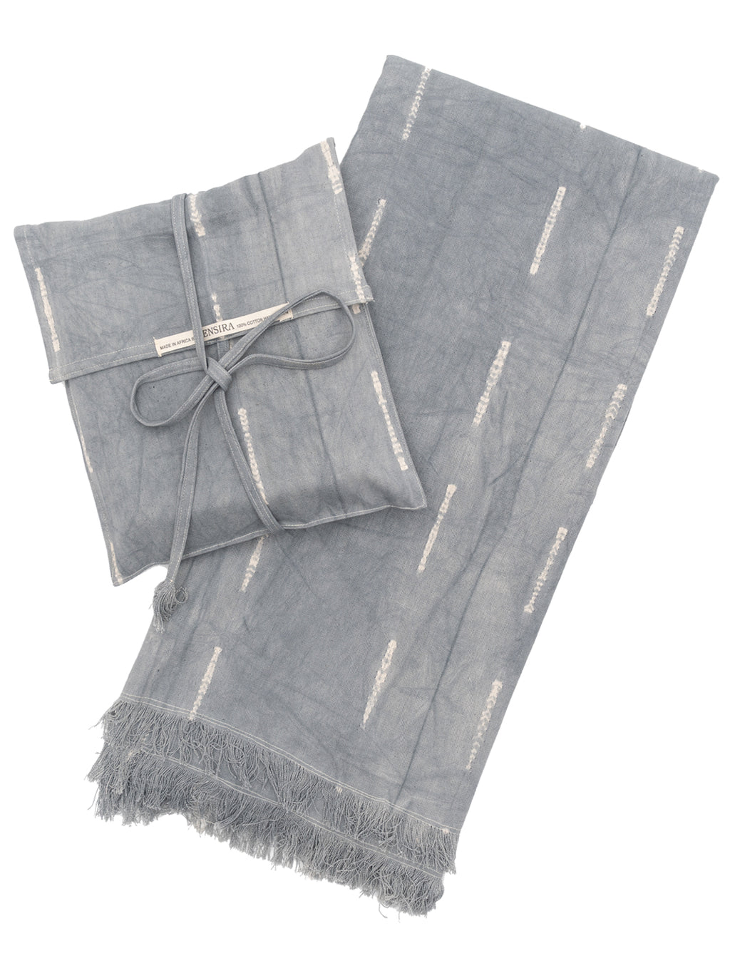 A gray cotton throw blanket with fringes and a matching pouch, displayed neatly folded.