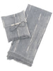 A gray cotton throw blanket with fringes and a matching pouch, displayed neatly folded.